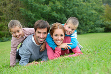 Fototapeta na wymiar Portret szczęśliwa rodzina leżąc w trawie