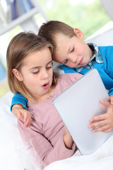 Children using electronic tablet at home