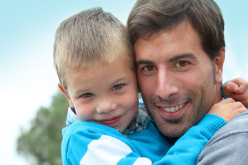 Portrait of father holding child in arms
