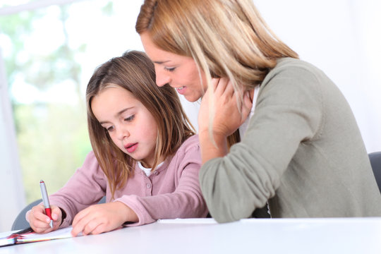 Mother And Daughter Doing Homework At Home