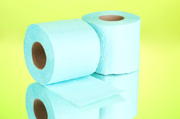 blue rolls of toilet paper on green background