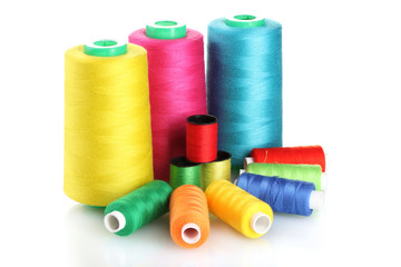 Many-coloured bobbins of thread isolated on white