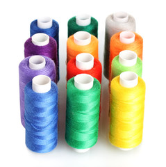 Many-coloured bobbins of thread isolated on white