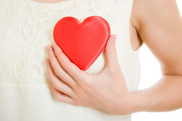 Obraz premium The girl pushes the heart to the chest on a white background.