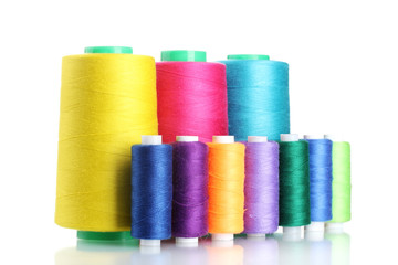 Many-coloured bobbins of thread isolated on white