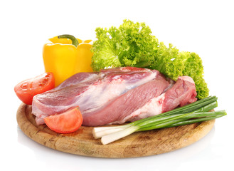 Raw meat and vegetables on a wooden board isolated on whitе