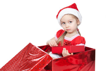 Little girl sitting in a large Christmas present box over white