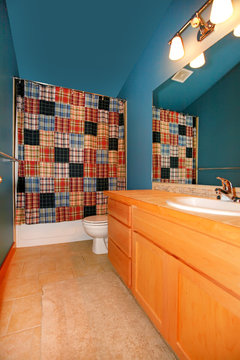 Dark Blue Bathroom With Wood Cabinet And Sink.