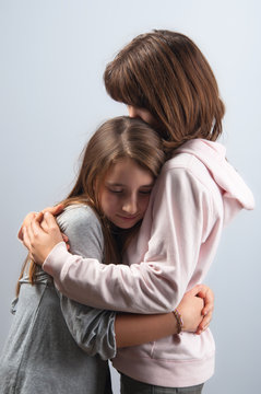Teenage girls hugging each other in mutual support