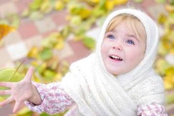 Портрет маленькой красивой девочки в белом платке осенью