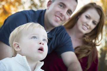 Cute Child Looks Up to Sky as Young Parents Smile