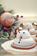 Fototapeta na wymiar Two marshmallow snowmen biscuits with Christmas decorations