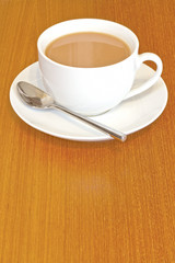 Cup of tea with saucer on wooden talbe