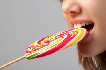 Detail of the beautiful girls face with huge lollipop