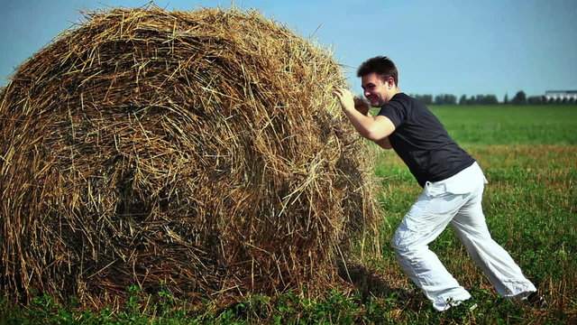Young man fighting with haystack