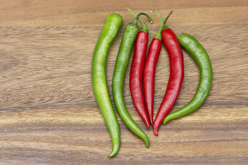 Red hot chili peppers over wooden background