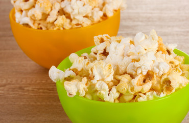 popcorn in bright plastic bowls on wooden table