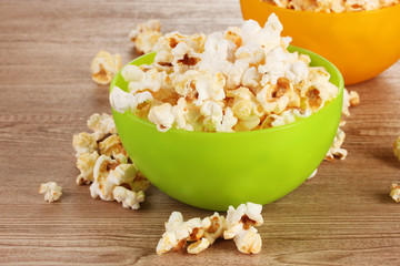 popcorn in bright plastic bowls on wooden table