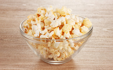 popcorn in glass bowl on wooden table