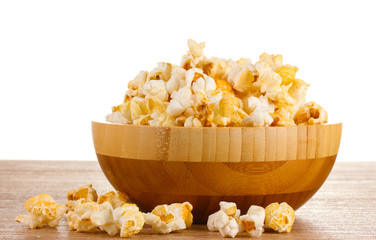 popcorn in wooden bowl on wooden table on white background