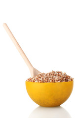 Boiled buckwheat in a yellow bowl isolated on white