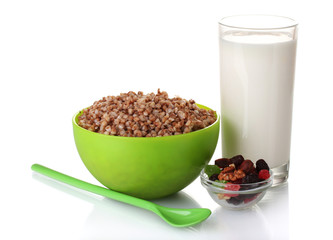 Boiled buckwheat in a green bowl a glass of milk isolated