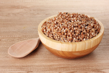 Boiled buckwheat in a wooden bowl wooden background