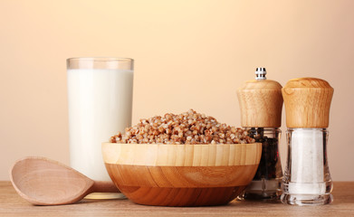 Boiled buckwheat in a wooden bowl with a glass of milk