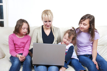 Family sitting on the sofa and using laptop