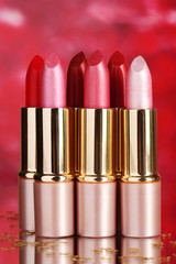 beautiful lipsticks on red background