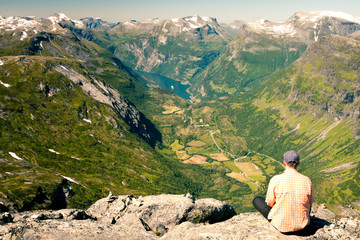 Young man looking to a Geiranger fjord