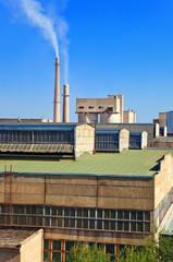 Large factory with smoking chimneys against the blue sky