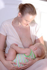 Young mother is breast-feeding her little child.