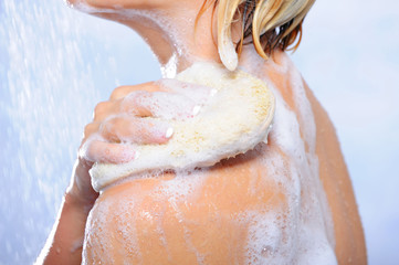 Woman washing body under shower