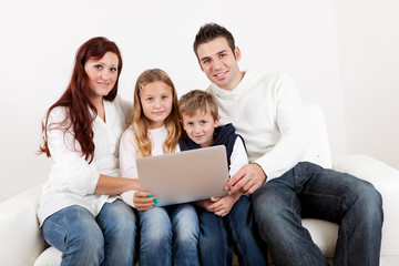 Fototapeta na wymiar Happy family using laptop at home
