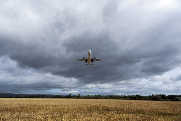 Fototapeta na wymiar Samolot lecący nad pola