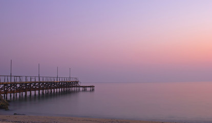 Fototapeta premium Iron bridge in the sea at dusk