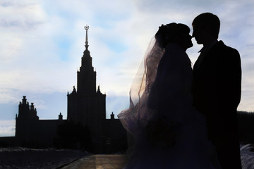 Silhouettes and profiles of bride and groom at winter outdoors,