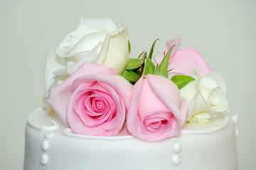 Pink roses on wedding cake.