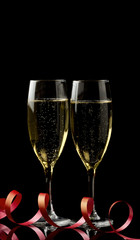 Two glasses with white wine over black background.