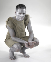 bodypainted poor man cowering on the ground