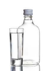 Bottle of vodka and wineglass isolated on white