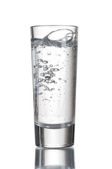 Vodka poured into a glass isolated on white