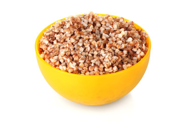 Boiled buckwheat in a yellow bowl isolated on white