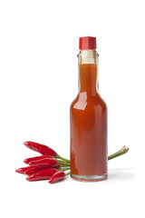 Bottle with hot chili pepper sauce and fresh tabasco peppers