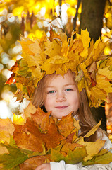 Cute smiling girl in a wreath of red viburnum on the head