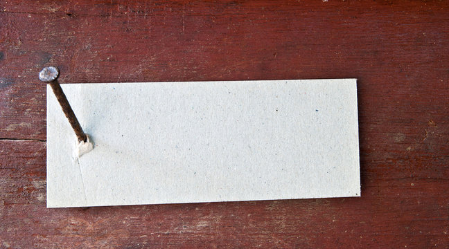 Paper label attached on wood wall with nail