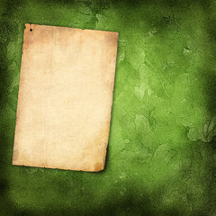 Old paper on grunge background with green leaves