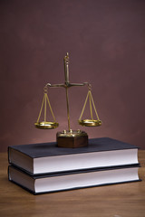 Scales of justice and gavel on desk with dark background
