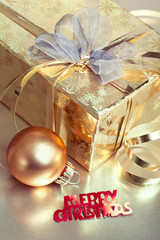 Christmas composition with gift box and bauble, closeup shot